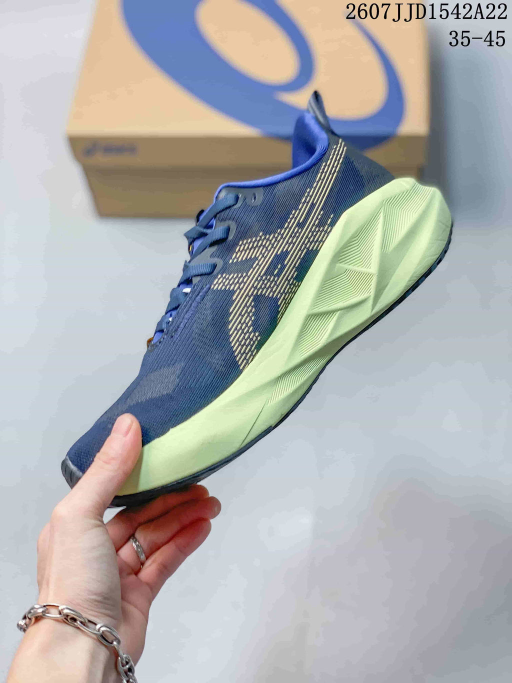Side profile showing the navy mesh upper, patterned side design, lime midsole and dark outsole.