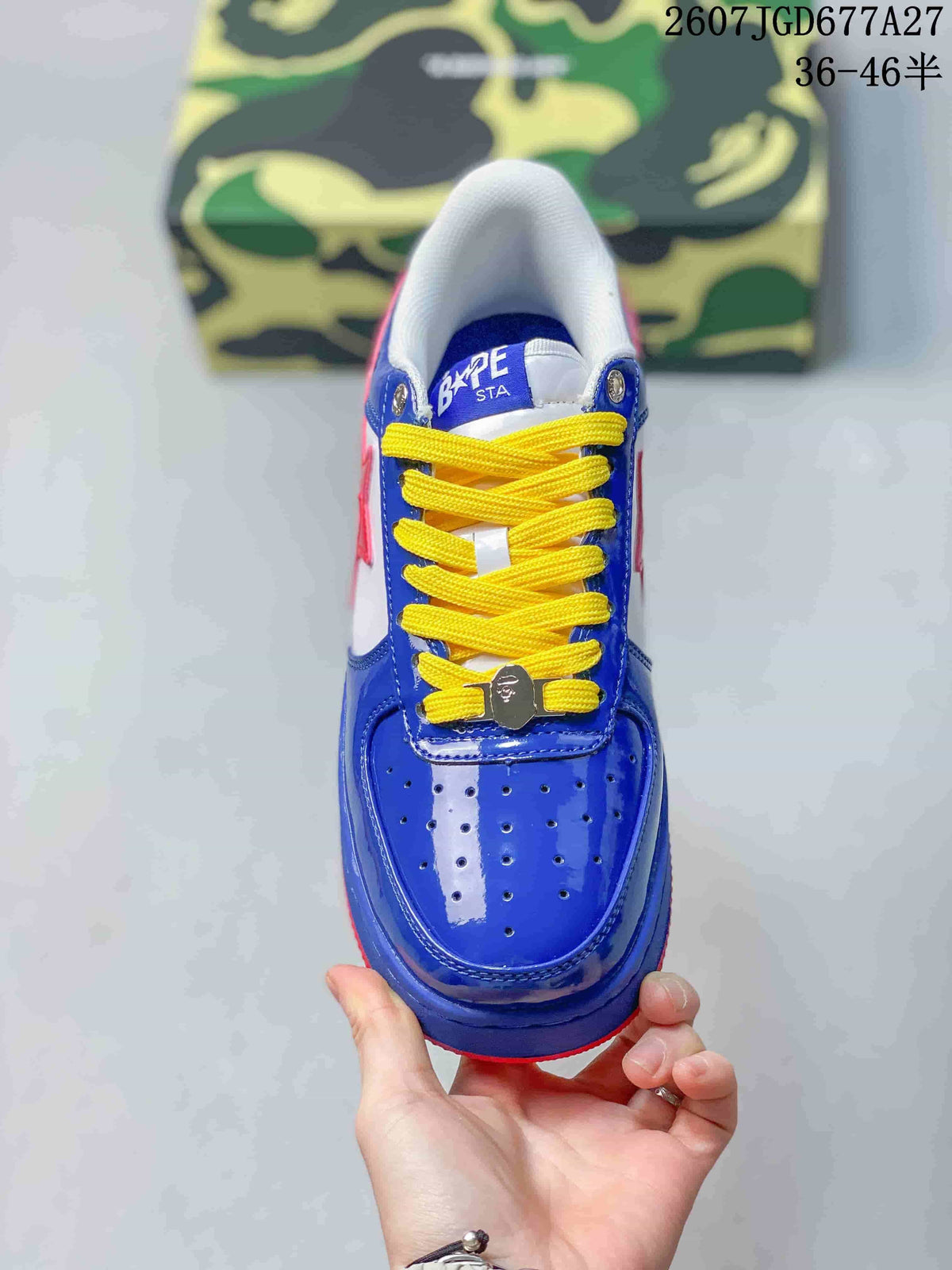 Top view of a blue low-top sneaker with perforated toe detailing, yellow laces, and BAPE STA tongue branding.