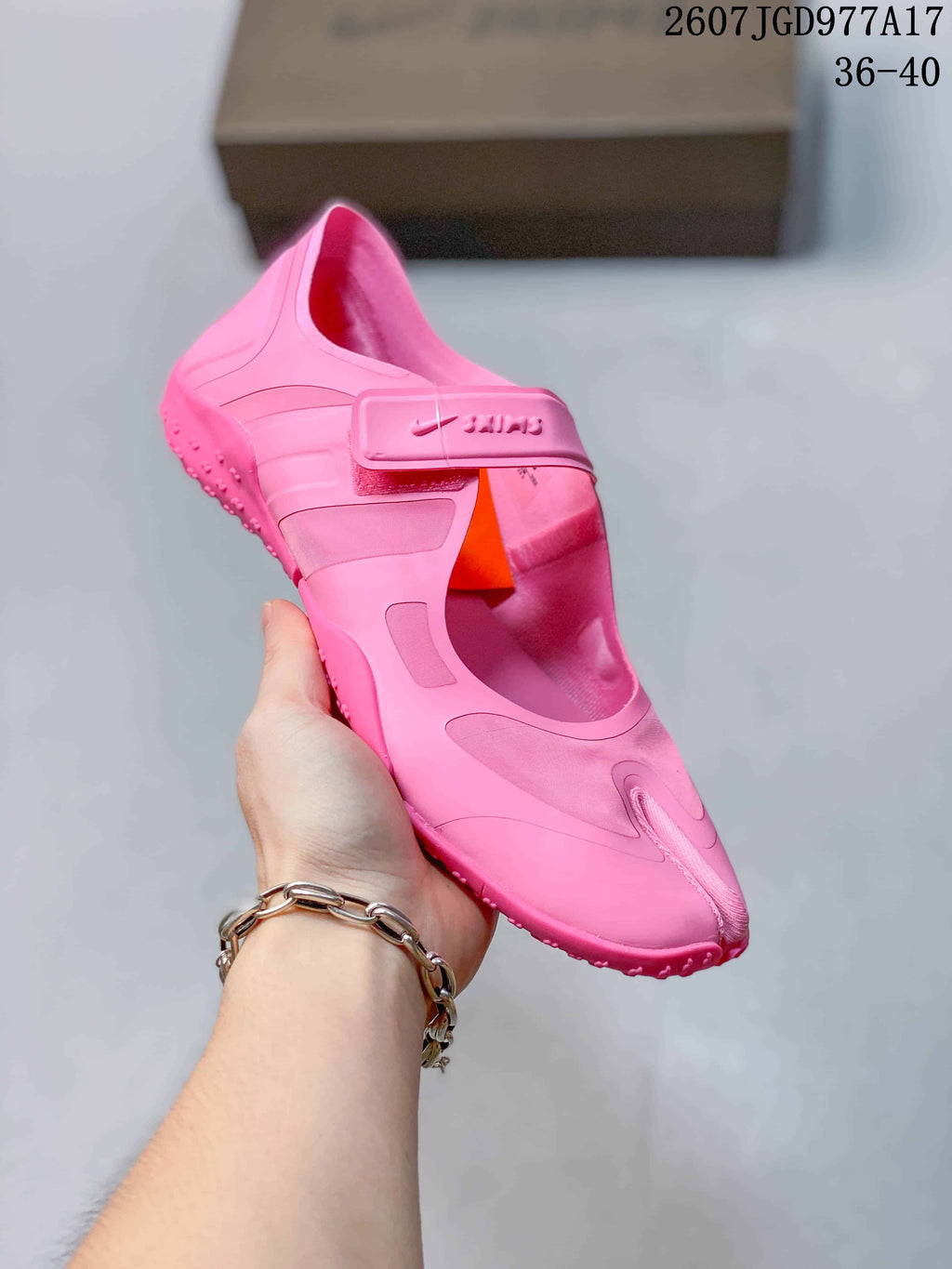Angled close view of the pink Nike x SKIMS sneaker showing the split-toe front, strap closure and side panels.