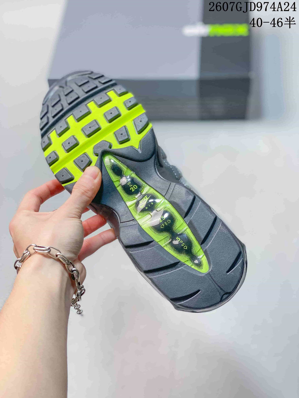 Close view of the sneaker outsole showing black tread, neon green sections and visible air cushioning elements.