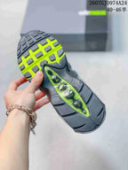 Close view of the sneaker outsole showing black tread, neon green sections and visible air cushioning elements.