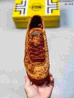 Top view of the brown sneaker showing its rounded toe, dark red laces and tongue branding.
