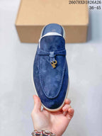 Top view of the navy loafer mule showing moccasin-style stitching, vamp strap, and gold-tone hanging charm.