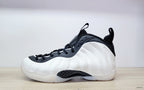Side view of a white Nike Air Foamposite One high-top with black collar and dark patterned midfoot detail
