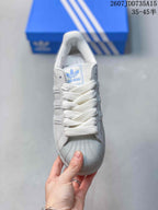 Top view showing the white laces, shell toe, and blue tongue branding.