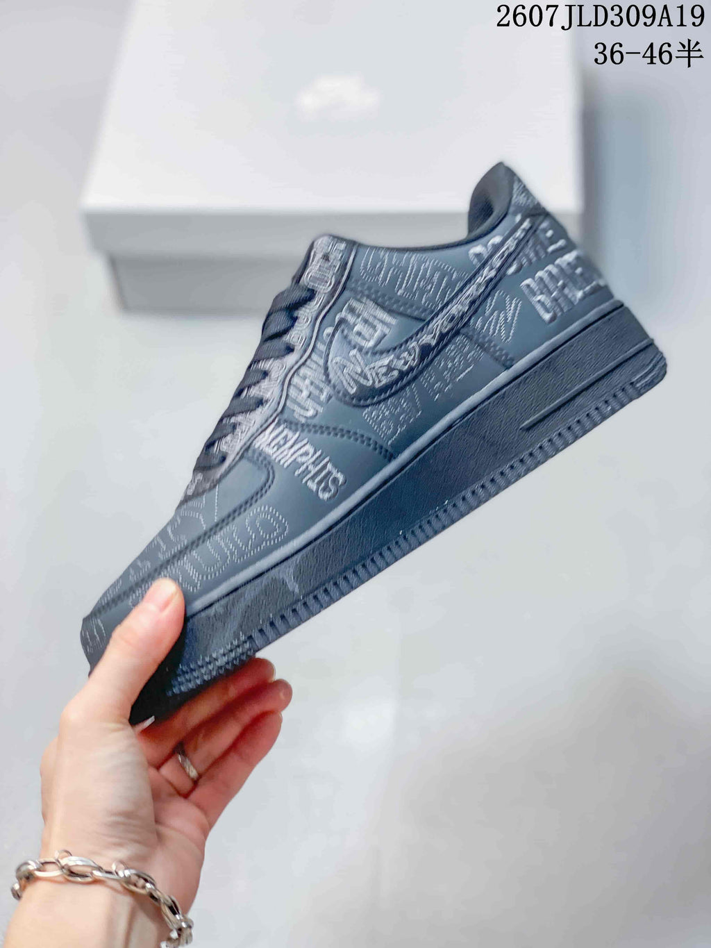 Side profile of the dark gray low-top sneaker showing the Swoosh, graphic lettering and textured outsole edge.