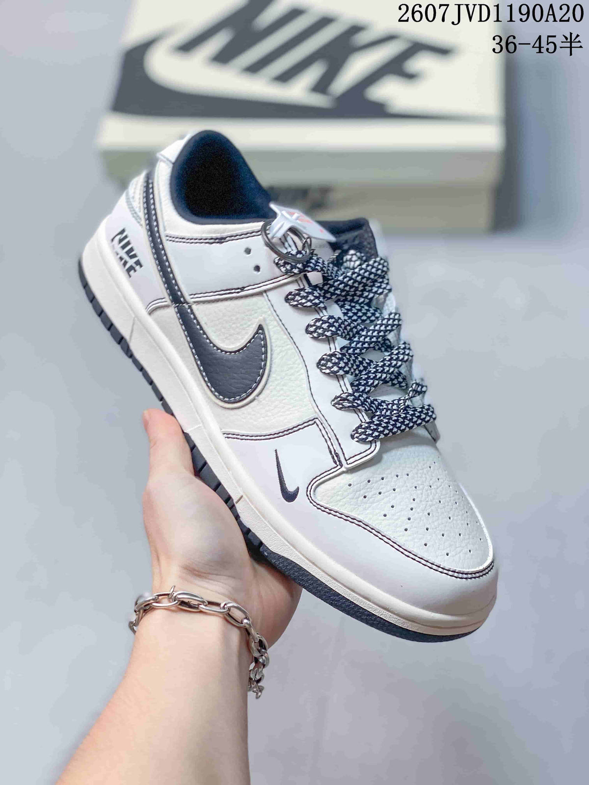 Angled side view showing the off-white and black color blocking, dark Swoosh, patterned laces, and low-profile rubber sole.