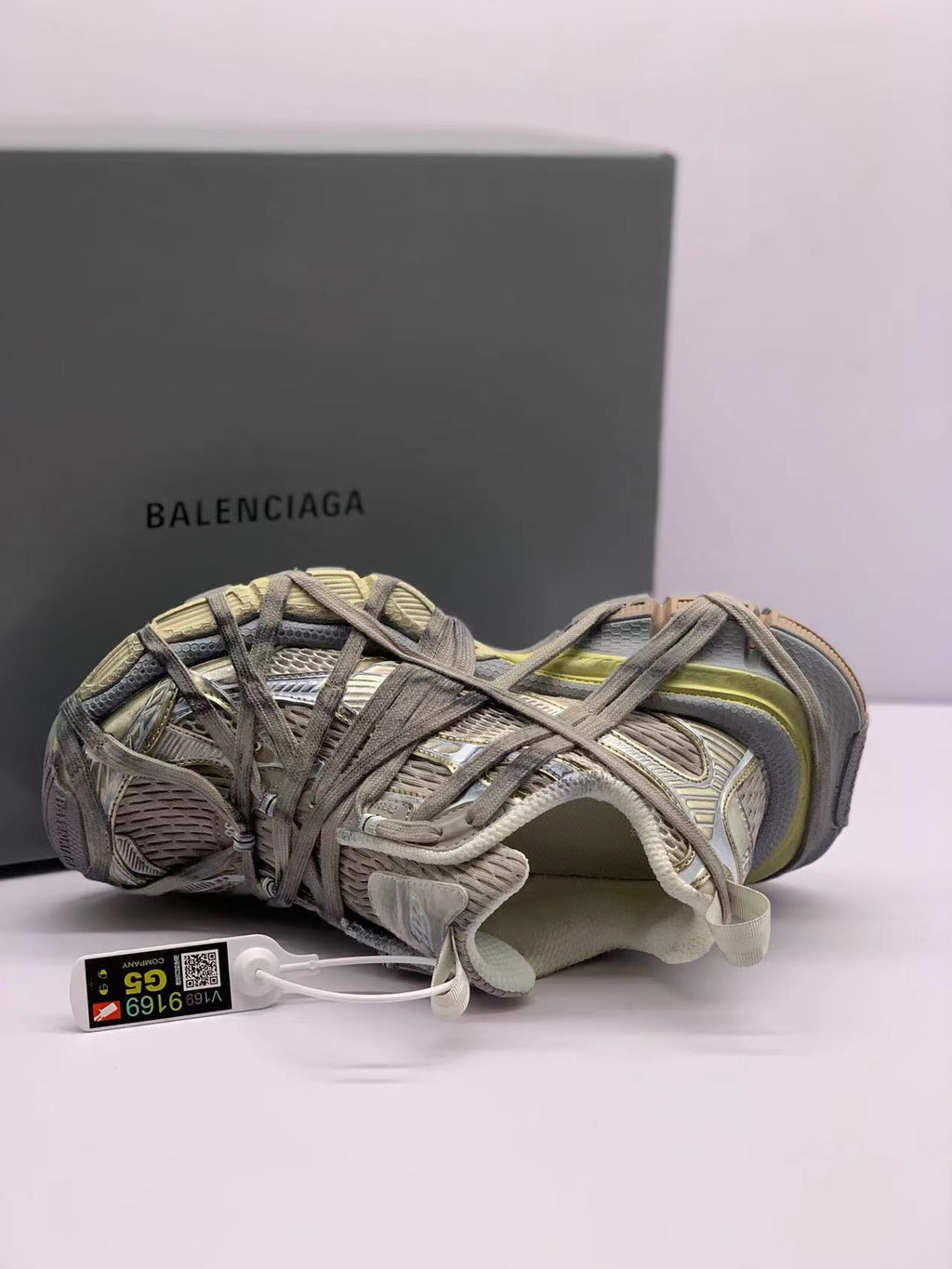 Top-side view of one sneaker showing the layered upper, interior padding, lace arrangement, and attached tag.