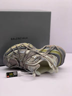 Top-side view of one sneaker showing the layered upper, interior padding, lace arrangement, and attached tag.