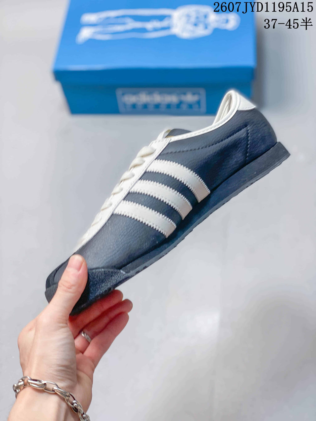 Side profile showing the navy upper, white three stripes and low-top silhouette.