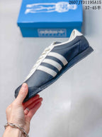 Side profile showing the navy upper, white three stripes and low-top silhouette.