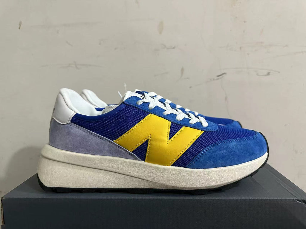 Side view of a New Balance U370 sneaker with a yellow logo and gray heel panel