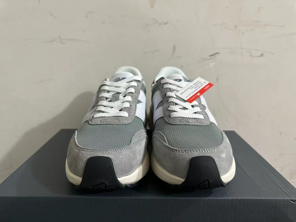 Front view of gray and white New Balance U370 sneakers with white laces.