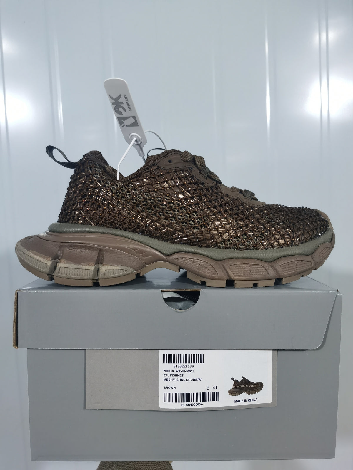 Side profile of the brown sneaker displayed on its box; the label shows style code 0523, brown color, and size E 41.