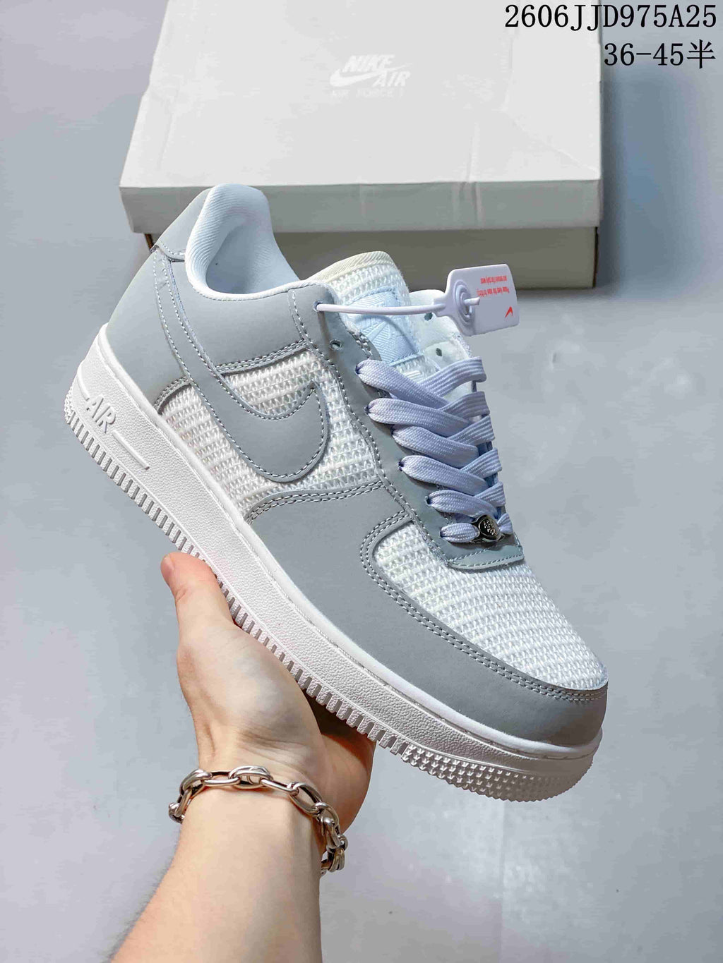 Angled side view of the light grey and white Nike Air Force 1 '07 sneaker showing the Swoosh, padded collar, white midsole, and textured outsole.