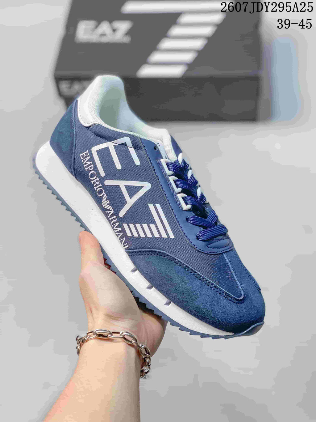 Close-up of a blue Emporio Armani EA7 sneaker with white side branding, a white midsole and a dark textured outsole.