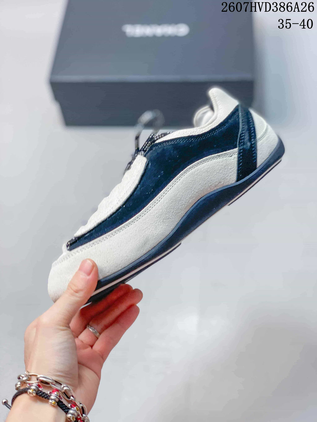 Side profile showing the low-top silhouette, black-and-white color blocking, and layered side panels.