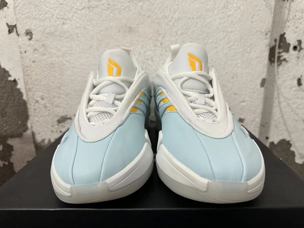 Front view showing the white laces and yellow tongue details on light blue Adidas Dame 9 shoes