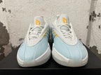 Front view showing the white laces and yellow tongue details on light blue Adidas Dame 9 shoes