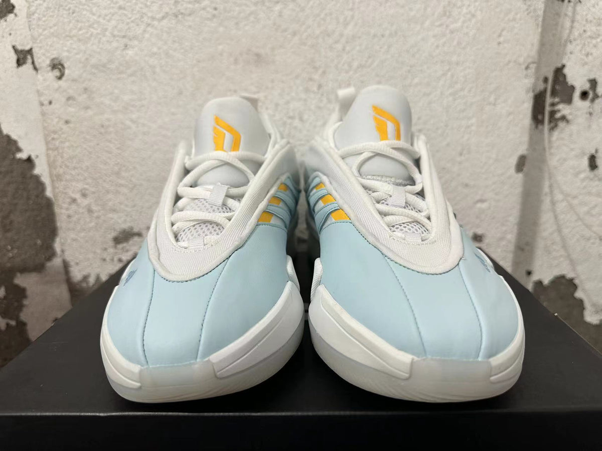 Front view showing the white laces and yellow tongue details on light blue Adidas Dame 9 shoes
