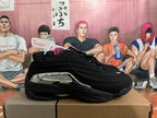 Side view of a black Nike sneaker with silver-tone side detailing.