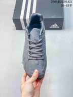Top view of the gray sneaker showing the lace-up construction, tongue, and textured toe panel.