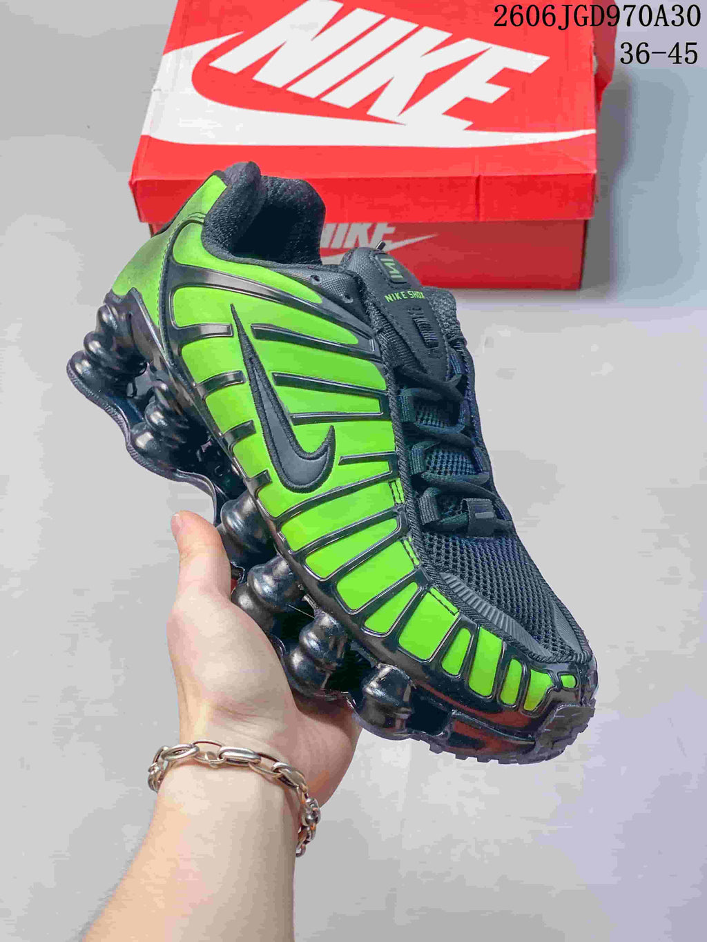 Angled side view of a black and vivid green Nike Shox TL sneaker
