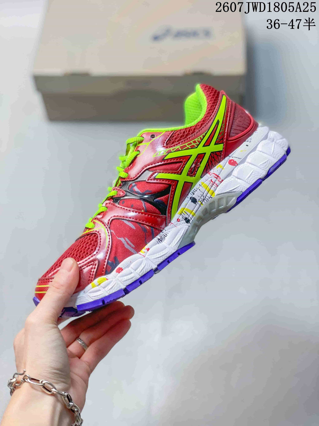Side profile showing the red mesh upper, neon green ASICS branding and layered white midsole.