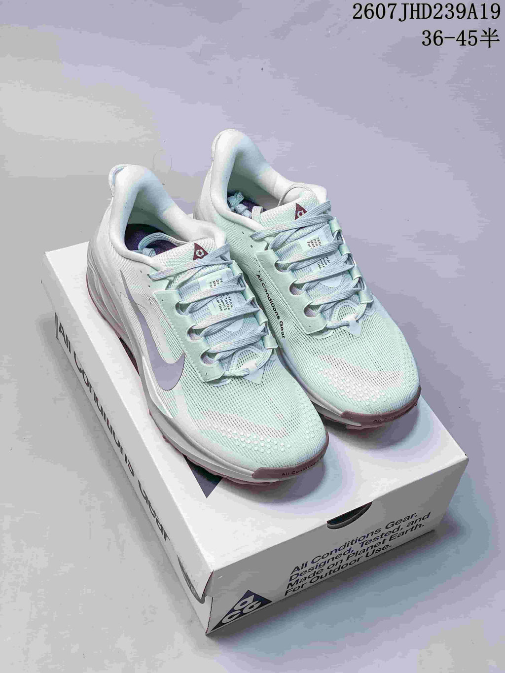 Pair of pale mint Nike ACG Pegasus Trail sneakers displayed on a branded shoebox.