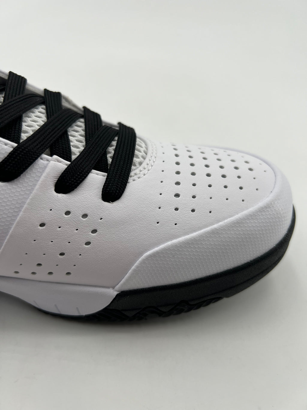 Close-up of the perforated toe, black laces, and black outsole edge