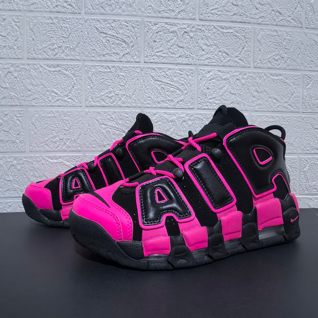 Pair of black and pink Nike Air More Uptempo sneakers at an angle