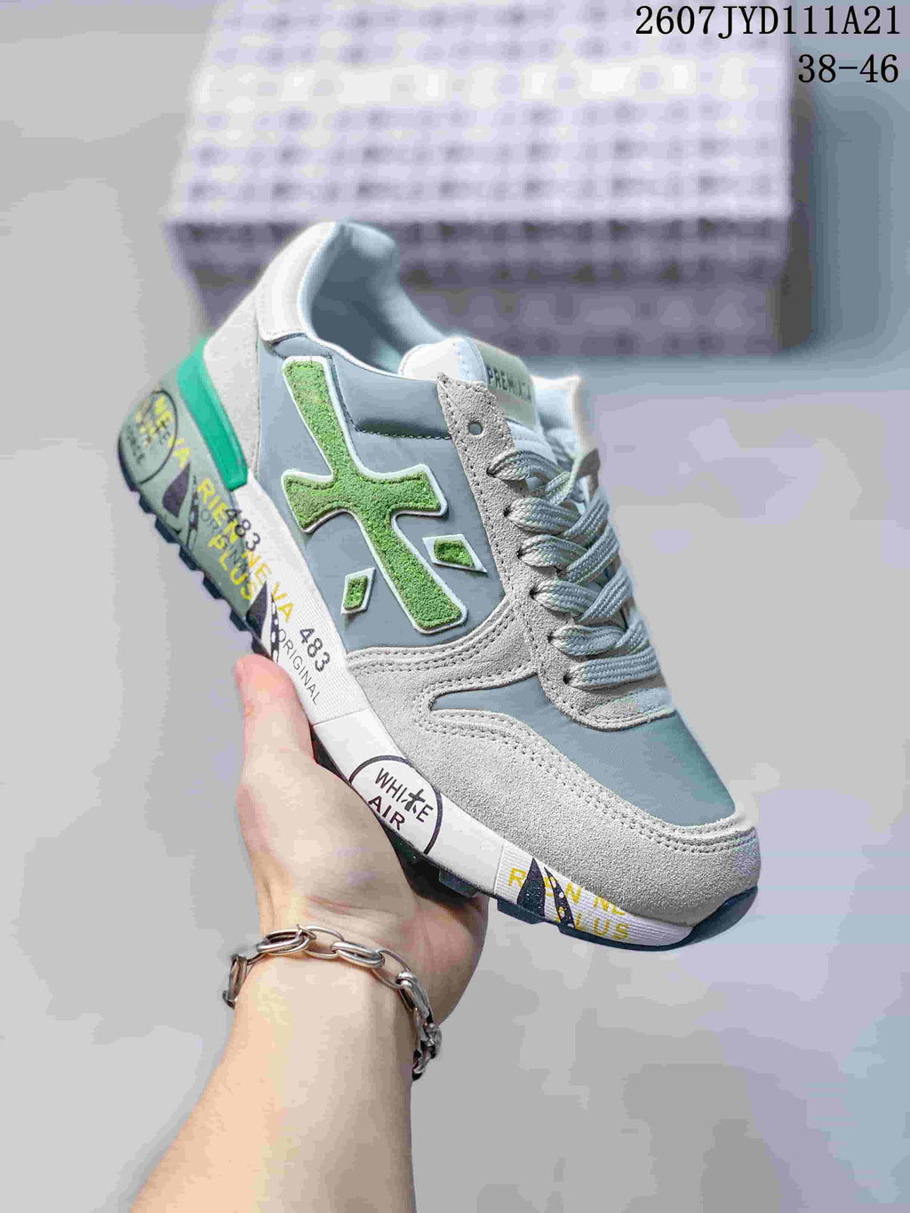 Angled side view of the sneaker highlighting the green side detail, gray upper, and printed midsole.