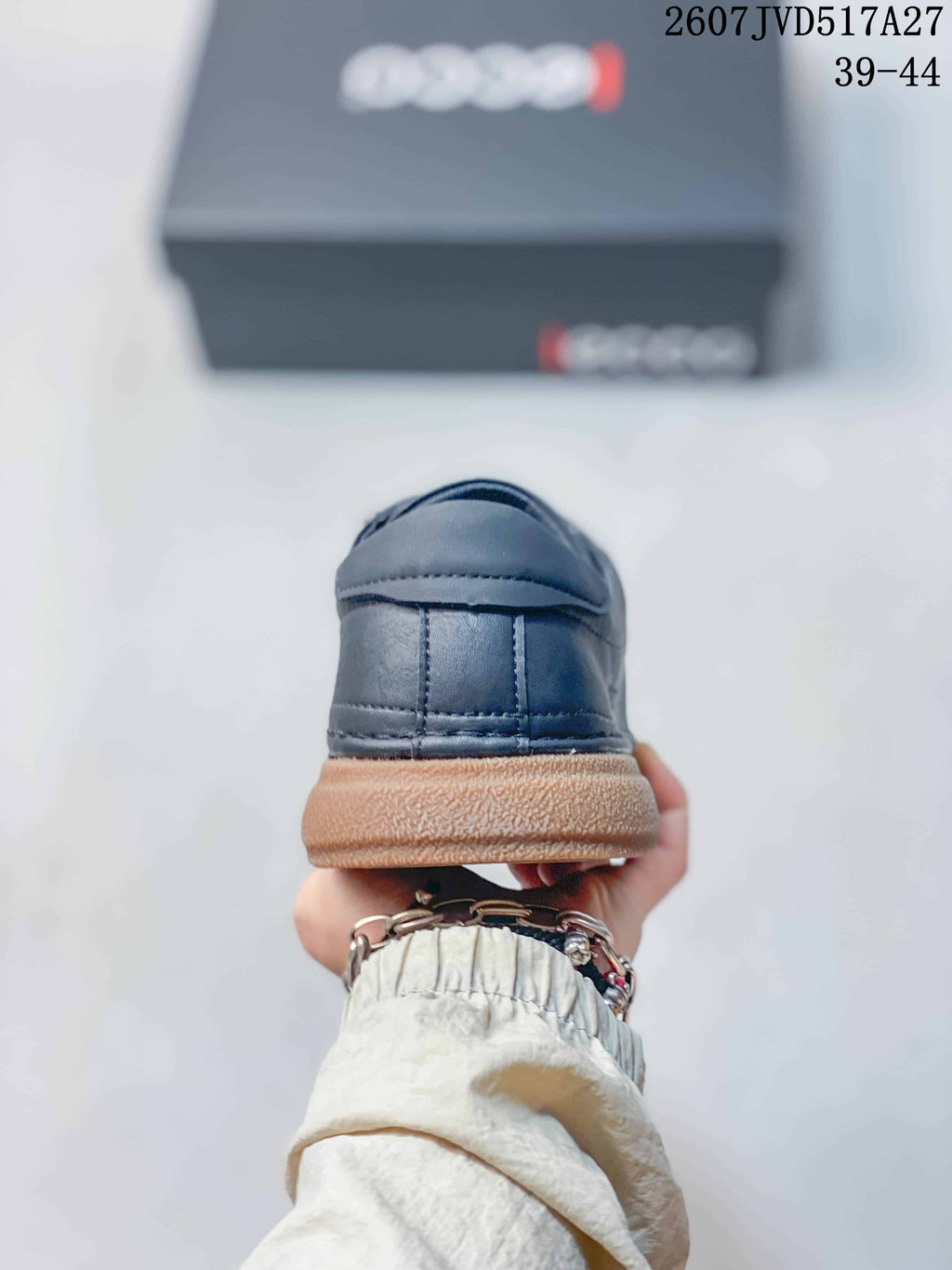 Rear view of a dark navy sneaker showing the stitched heel panel and contrasting gum-colored sole.