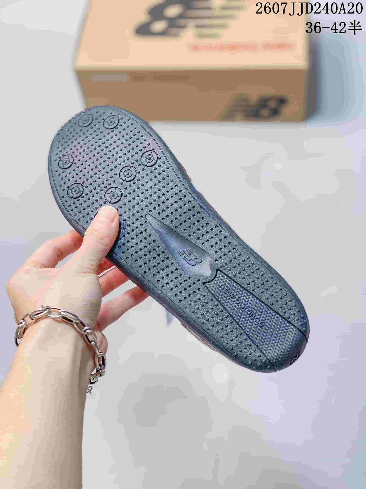 Close-up of the dark outsole showing raised circular traction elements and a textured tread pattern.