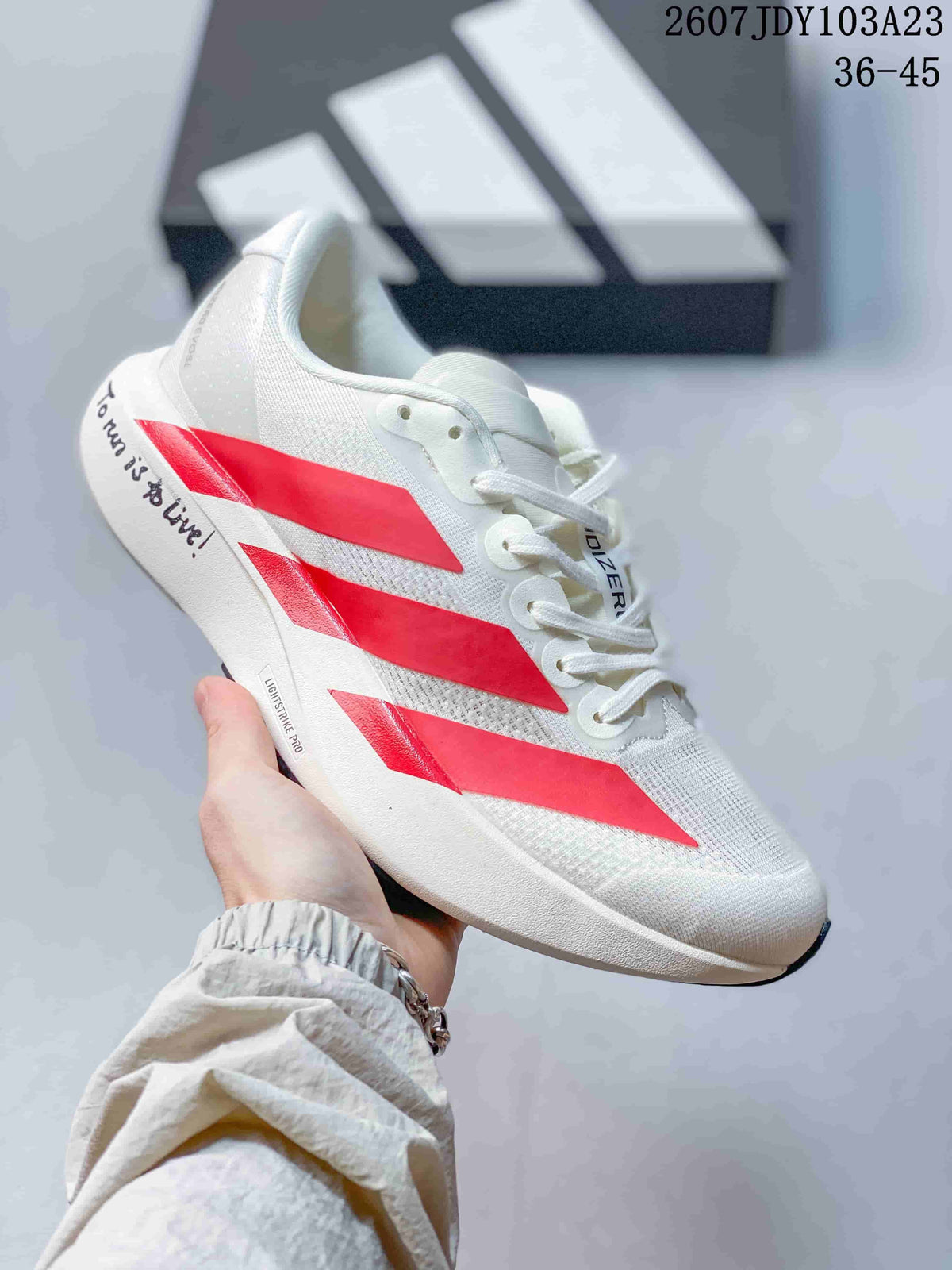 White adidas Adizero low-top sneaker with bright red side stripes and a white sole.