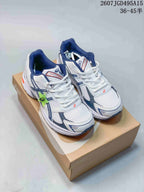 Pair of white ASICS GEL-1130 sneakers with navy and orange details displayed on a shoebox; image text shows style code 2607JGD495A15 and size range 36-45.5.