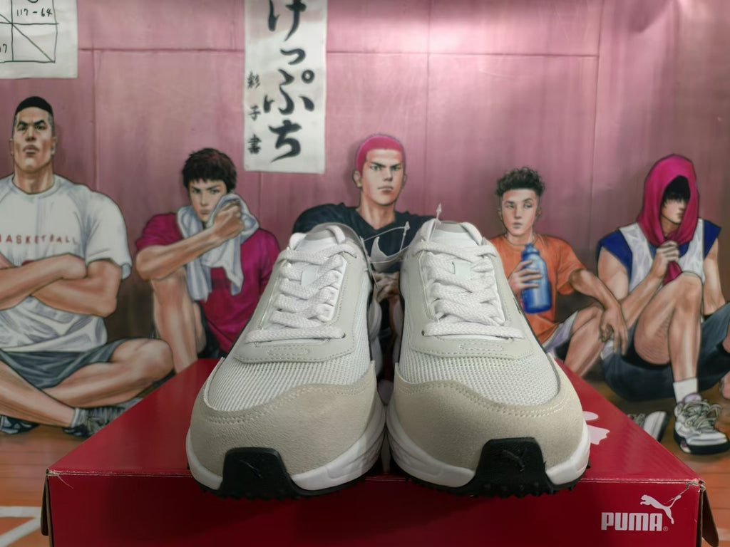 Front view of white and light gray PUMA sneakers with lace-up closure