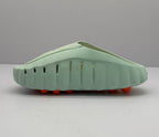 Opposite side profile showing ventilation openings, the sculpted light green sole, and orange circular outsole elements.