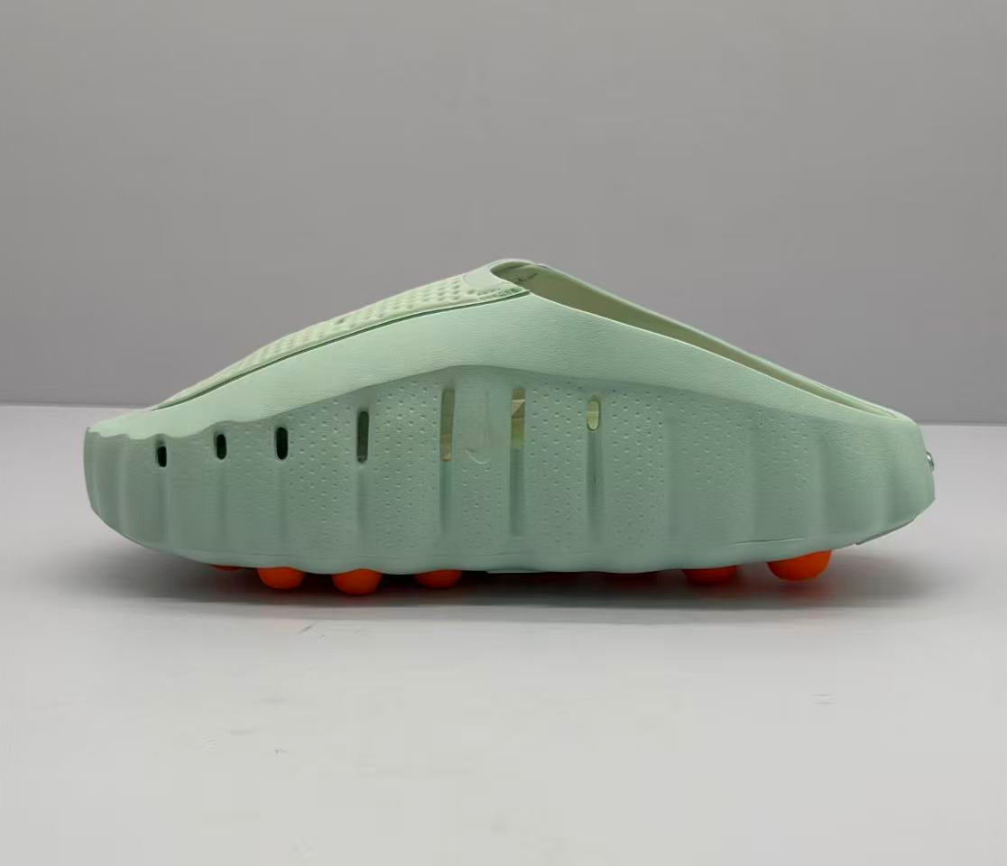 Opposite side profile showing ventilation openings, the sculpted light green sole, and orange circular outsole elements.