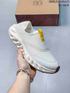 Close-up of a white slip-on shoe with a mesh-like upper and sculpted sole.
