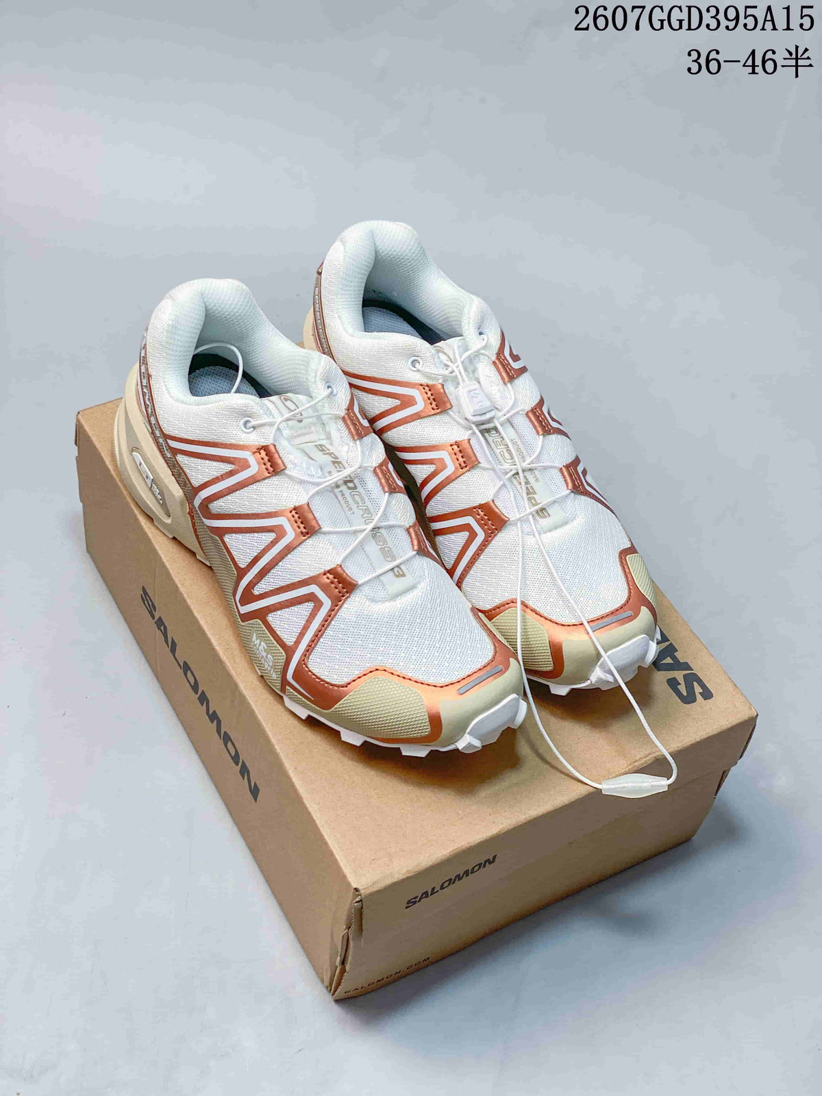 Pair of Salomon SPEEDCROSS 3 trail running shoes in white, bronze and cream on a Salomon shoe box; product code and size range are overlaid.