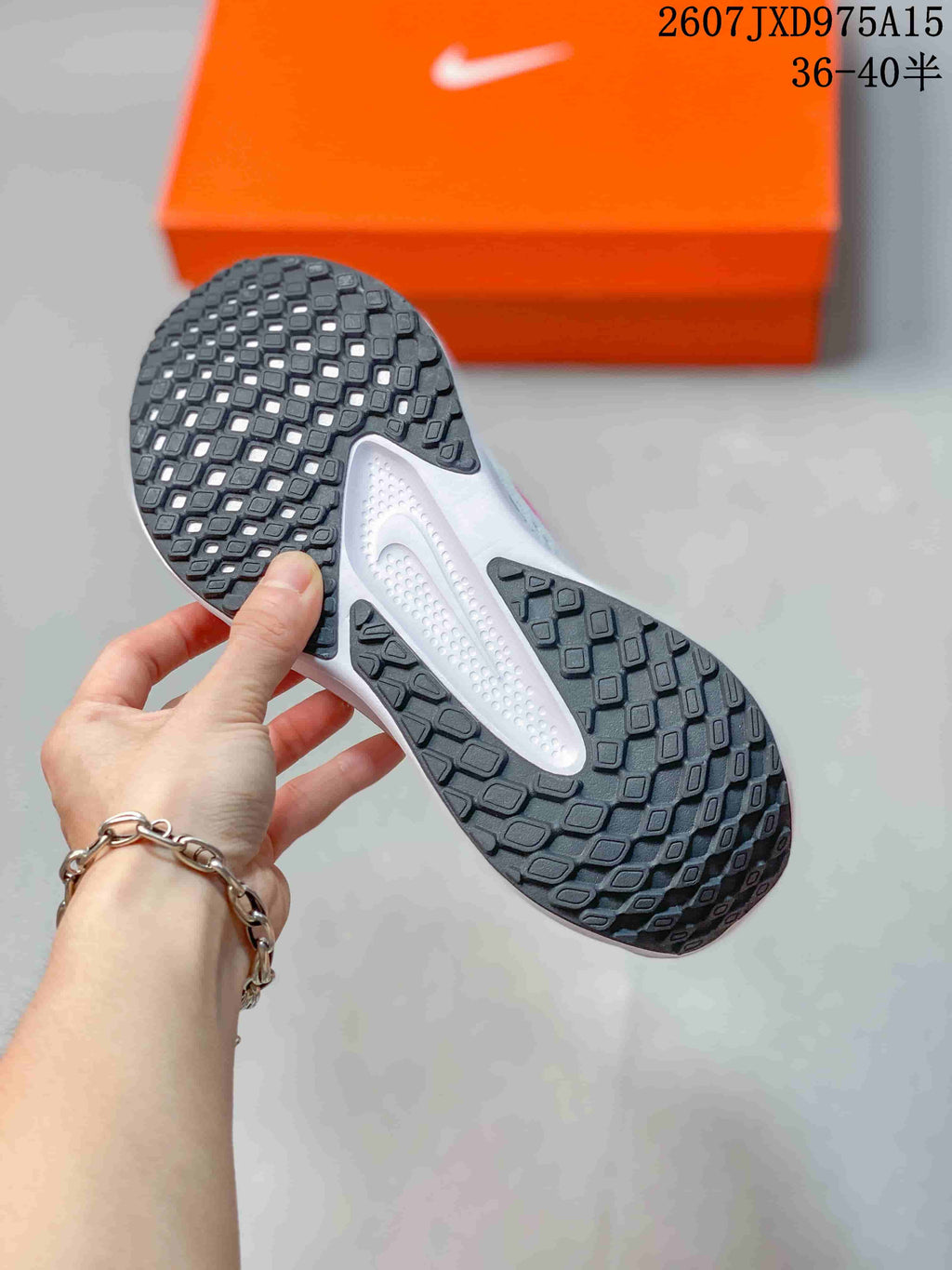 Close view of the black textured outsole and white midsole of a Nike running shoe.