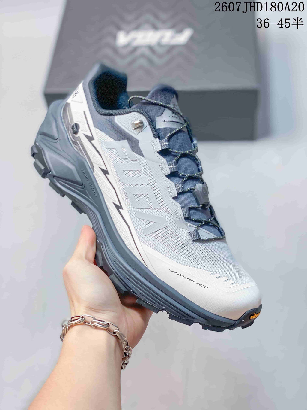Three-quarter side view showing the white and gray upper, dark outsole, lace system and reinforced heel.
