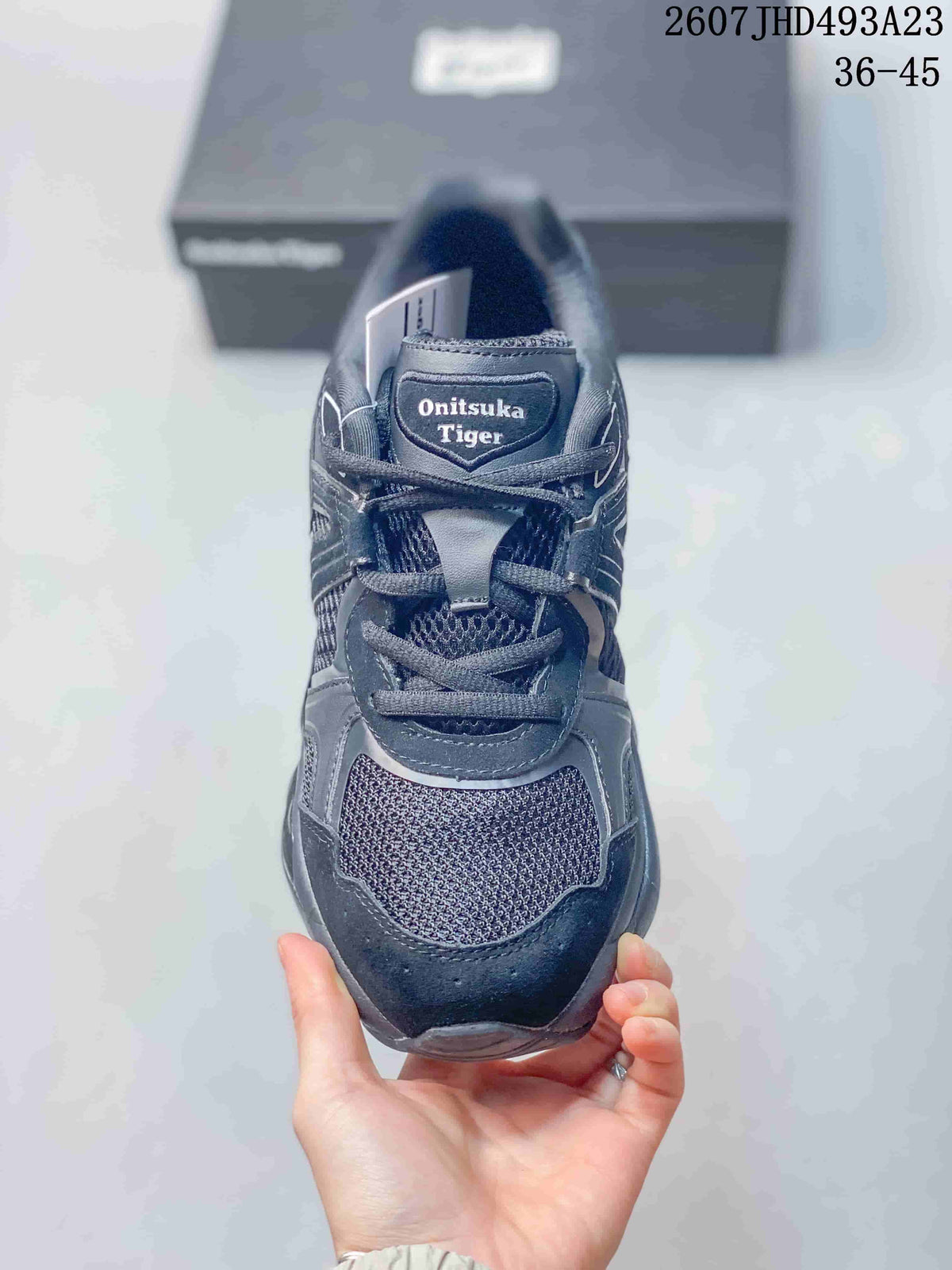 Top view of the dark Onitsuka Tiger sneaker showing the lace-up closure, mesh toe panel and tongue branding.