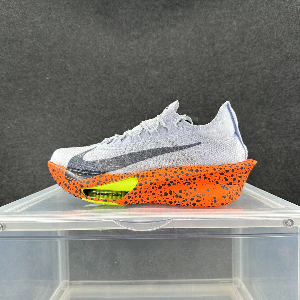 Side view of a white Nike Alphafly 3 running shoe with a black Swoosh, orange speckled midsole and bright lime accent.