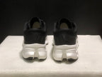 Rear view of the black sneakers showing padded collars, heel branding, and white midsoles.