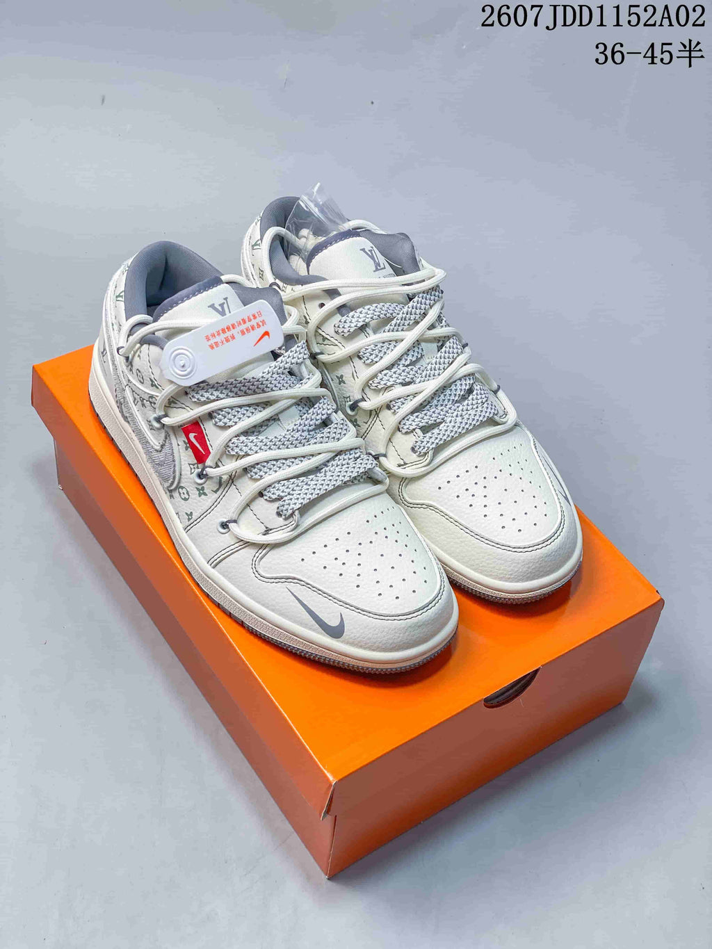 Pair of white low-top sneakers with repeating patterned panels and gray patterned laces.