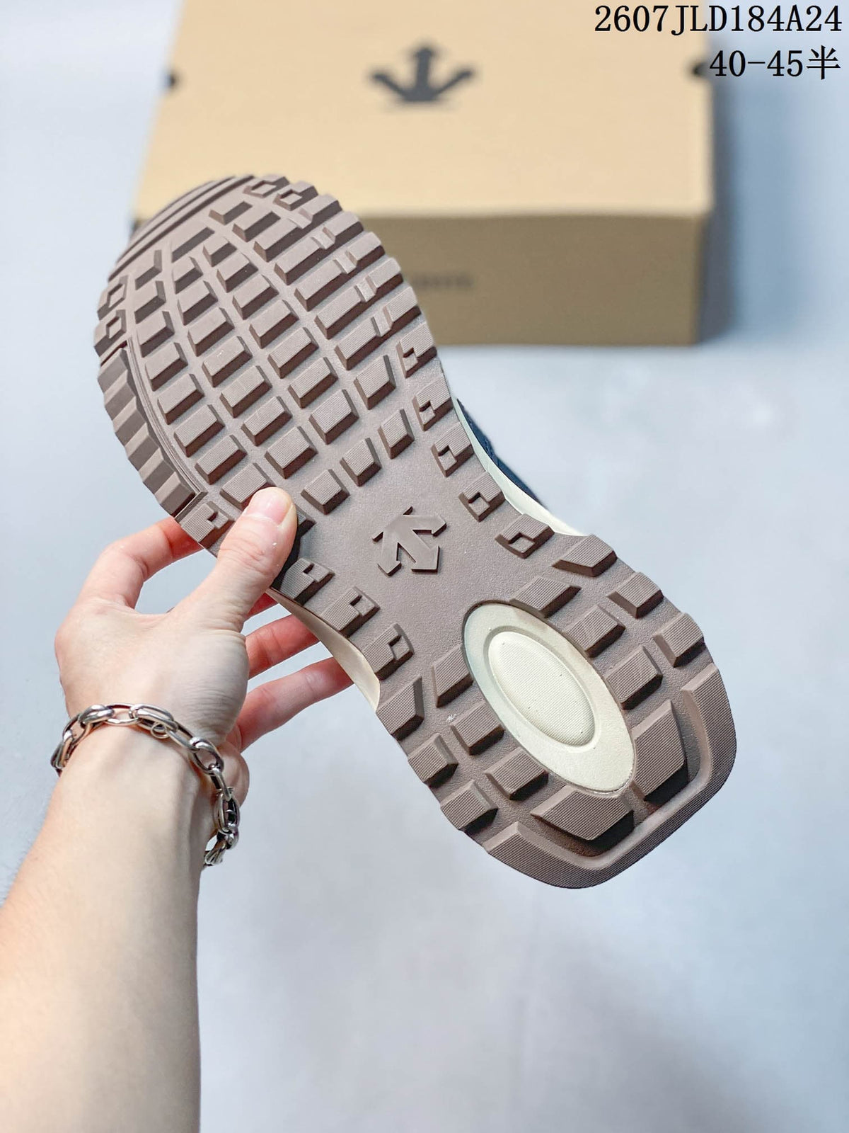 Close view of the sneaker outsole showing a block-pattern tread and central DESCENTE-style emblem.