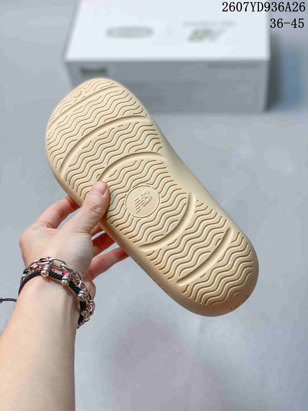 Close-up of the beige sandal outsole showing a repeating wavy traction pattern and embossed branding; image text shows sizes 36–45.