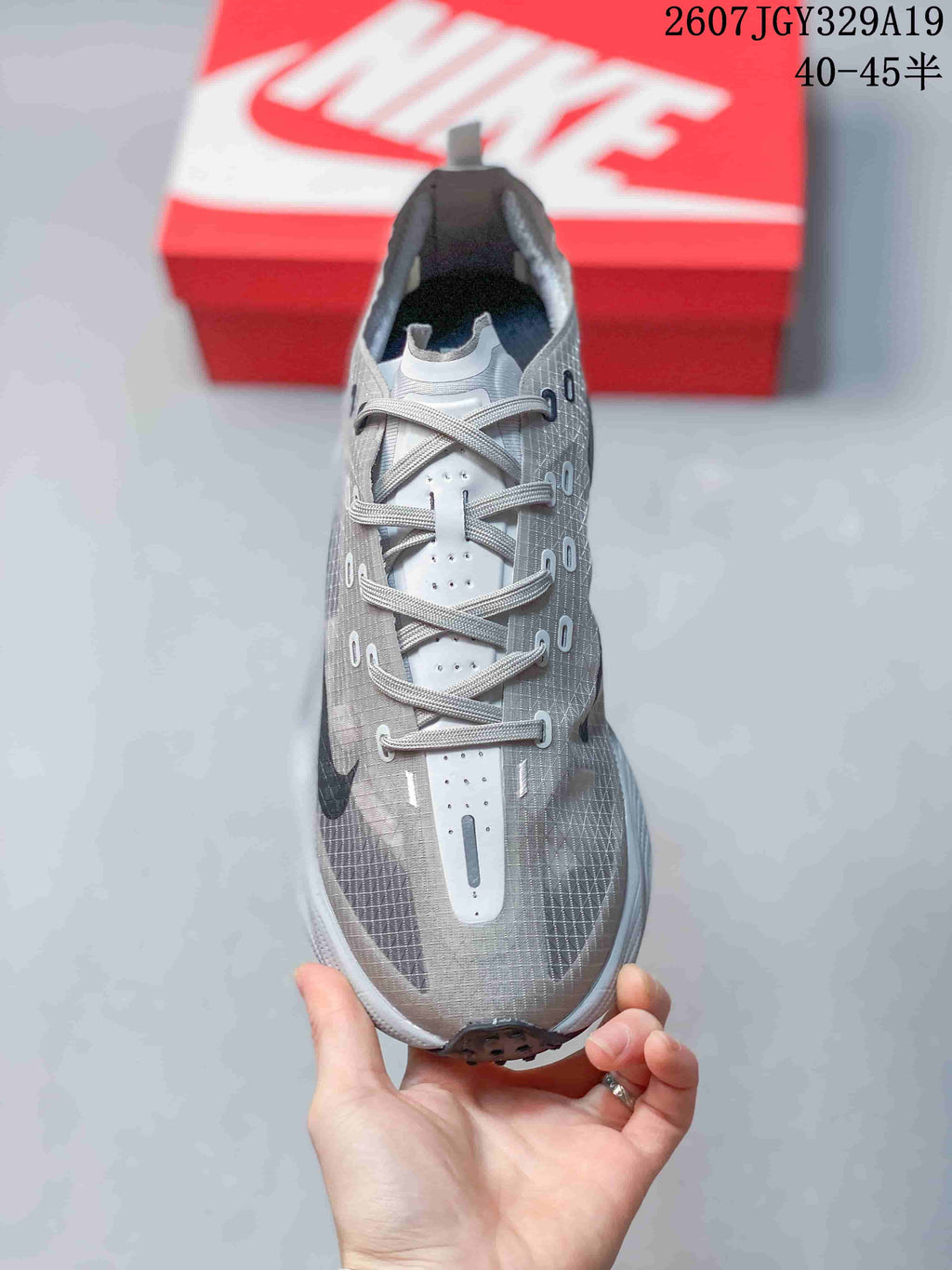 Top view of the gray lace-up sneaker showing the perforated tongue panel, eyelets, and dark side detailing.